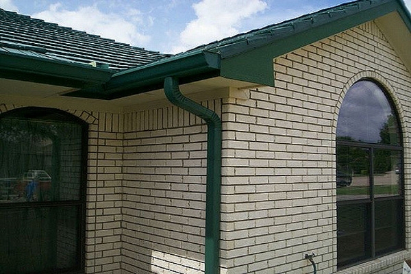a fascia style gutter system connected to a downspout