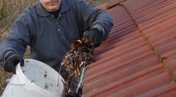 man collecting debris from gutters