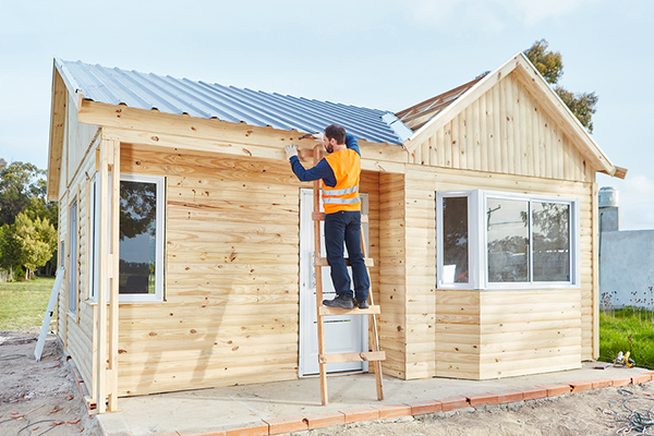 worker installing wood siding.