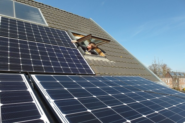 a boy looking through a window to check on high sloped roof solar panels