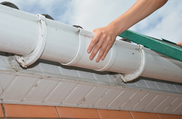 Hand holding white gutter section